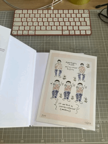 Gif showing an art print slide into the cover of a hardback.