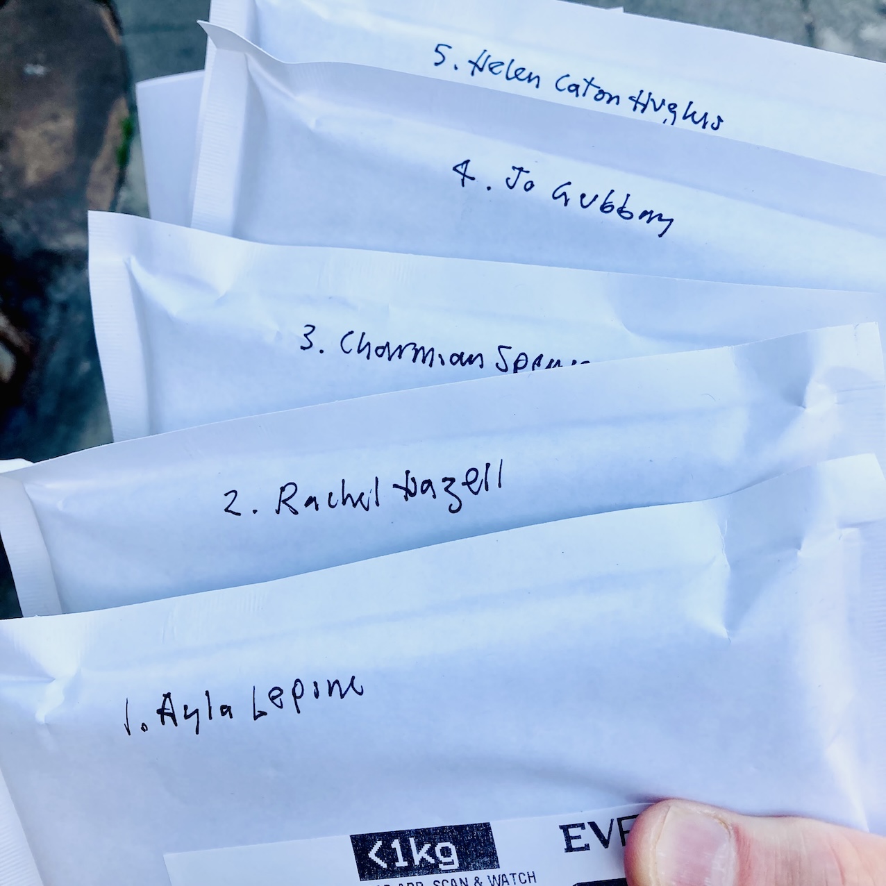 Five padded envelopes with handwritten names of recipients.