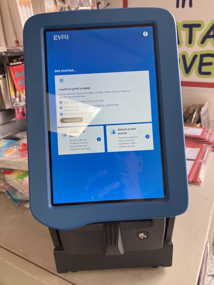 Similar photo of the Evri printer amid clutter, but this time with screen reading 'I want to print a label'. Similar photo of the Evri printer amid clutter, but this time with screen reading 'I want to print a label'.