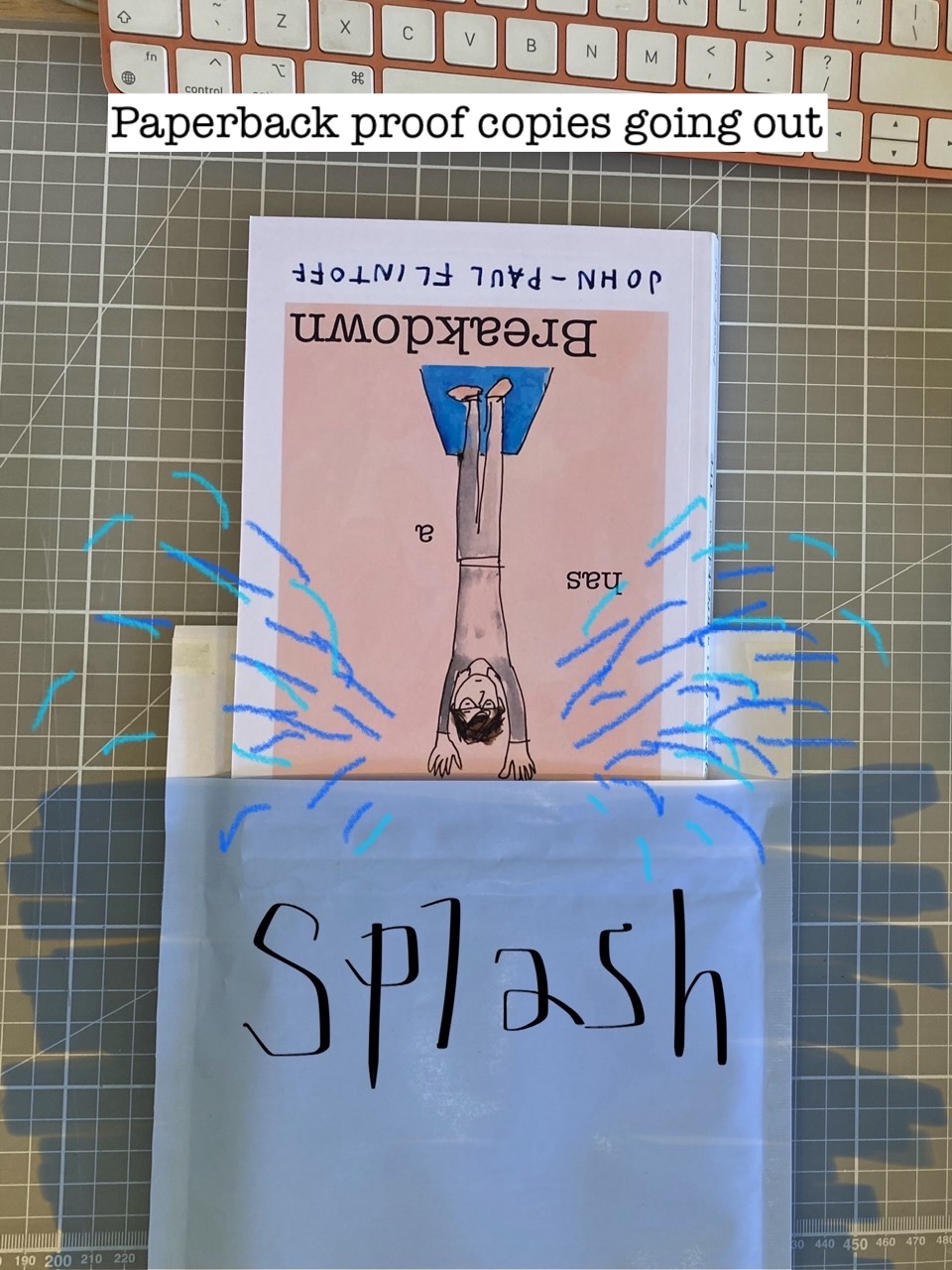Photo of paperback going into an envelope with simulated splashing drawn over it. Photo of paperback going into an envelope with simulated splashing drawn over it.