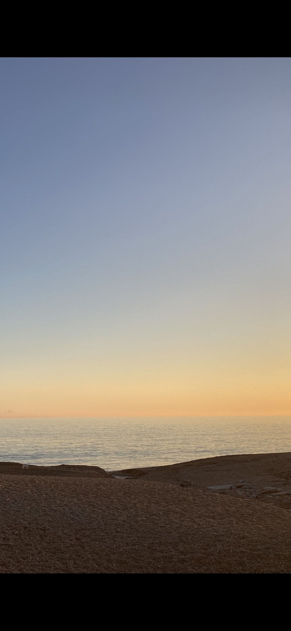 The right portion of the same scene as a tall screenshot - open sea, the sunset horizon and the shore The right portion of the same scene as a tall screenshot - open sea, the sunset horizon and the shore