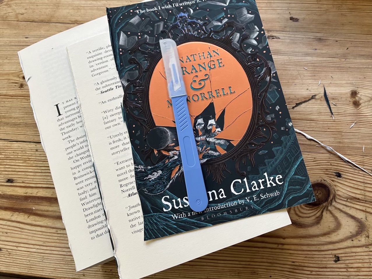 Photo from above of the cover of Jonathan Strange & Mr Norrell by Susanna Clarke, lying on top of two parts of the book.