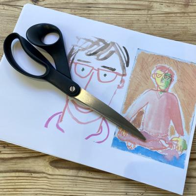 Two drawings of the Speccy Man on a single sheet of paper: one a smiling close up and the other sitting in lotus position with solemn expression. A pair of scissors lies across them.