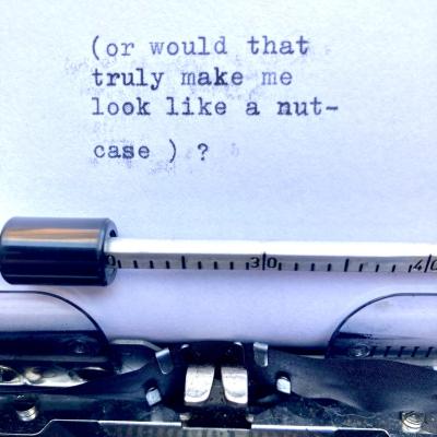 Text on paper in a manual typewriter, reading: 'or would that
truly make me
look like a nut-
case?'